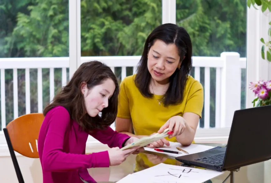 a woman and a girl looking at a piece of paper academia chino moderno